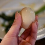 湯治玉子の殻をむくと、ほんのり色づいた卵が出現